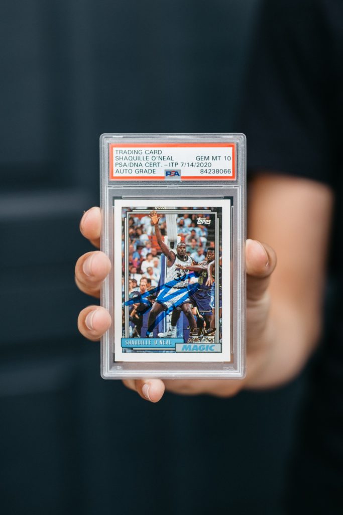 A person holding basketball trading card.