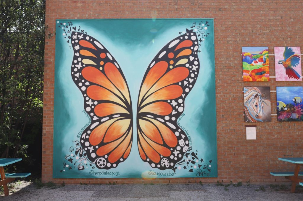 A mural of a butterfly on a brick wall.