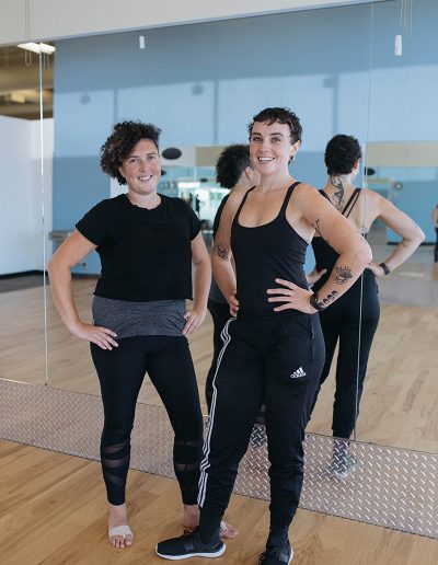 Two women from a starter company standing in front of a mirror in a dance studio.